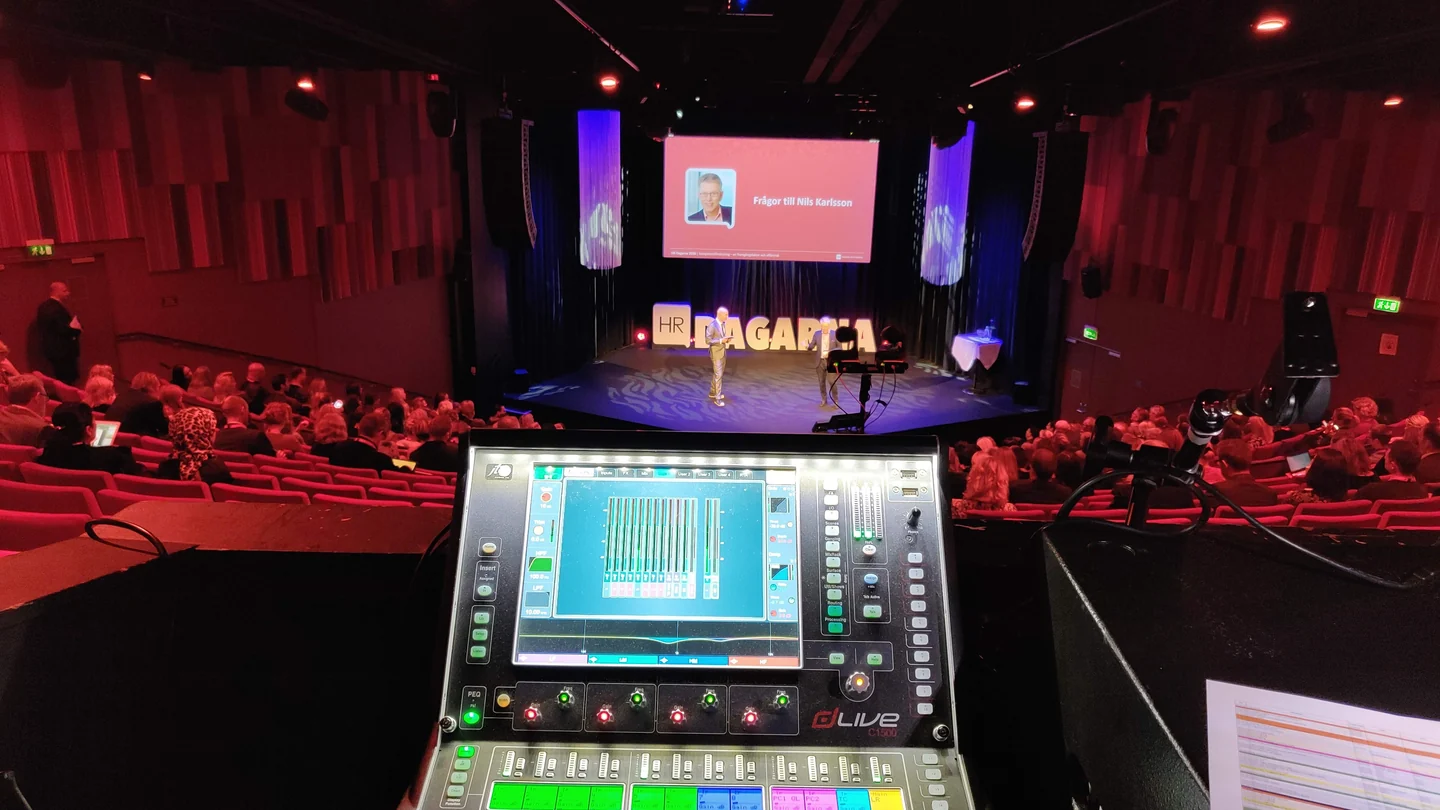 Mixing console overlooking a theatre stage during earlier live-production work.